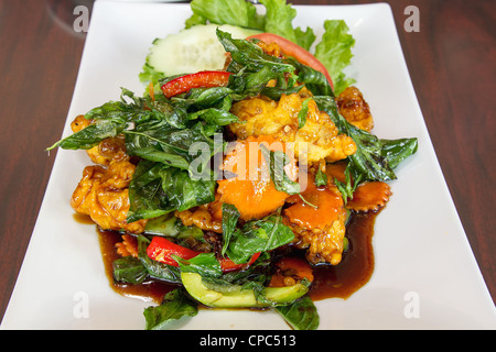 Thai Poulet frit croustillant avec des feuilles de basilic Tomate Concombre Poivron Vertical plat Banque D'Images