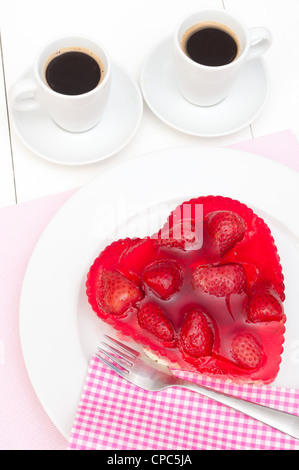 Gâteau aux fraises en forme de coeur et deux tasses de café Banque D'Images