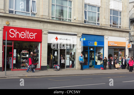 Une rangée de quatre boutiques de bienfaisance, l'abri, la Croix Rouge Britannique, Marie Curie et de l'arthrite Research UK sur Grand Moor Street à Bolton. Banque D'Images