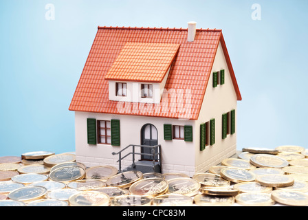 Maison modèle entouré par € de monnaie. Banque D'Images