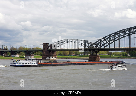 Barge à propos de la voile commerciale sous le pont de chemin de fer sur le Rhin, Cologne, Allemagne. Banque D'Images