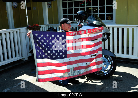 Un motard nous tend un drapeau américain en lambeaux qui comprend une image des tours jumelles et « septembre 11, 2001' Banque D'Images