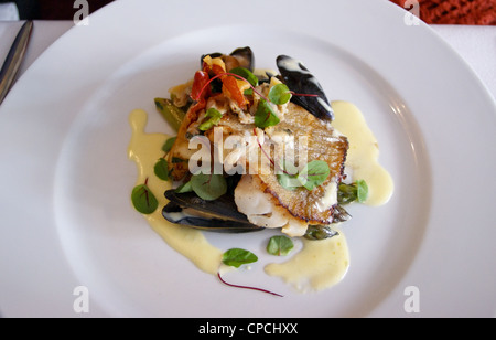 Le démarreur de coques, de moules et de la morue grillée avec bébé chard et sauce à la crème aigre, à Topes restaurant, Rochester, Kent, Angleterre Banque D'Images