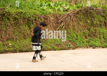 A mature basha (Miao) hommes femme waliking sur la rue, le sud de la Chine Banque D'Images