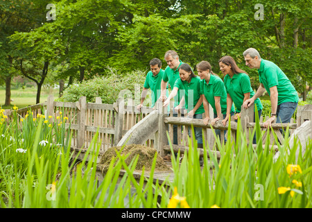 Jardiniers peering over fence in park Banque D'Images