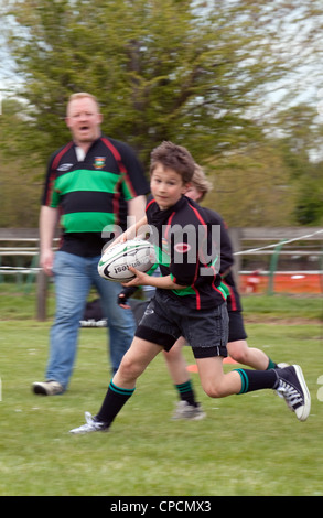 Rugby Junior - garçon exécutant avec la balle - motion blurred, Newmarket Suffolk Juniors Rugby Club UK Banque D'Images