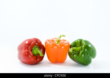 Rangée de vert, orange et rouge des poivrons de couleur sur un fond blanc. Banque D'Images