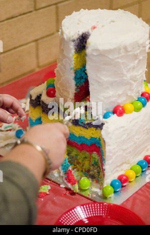 Grand gâteau d'anniversaire de l'enfant étant coupé Banque D'Images