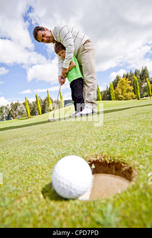 L'enseignement de l'homme hispanique boy pour jouer au golf Banque D'Images