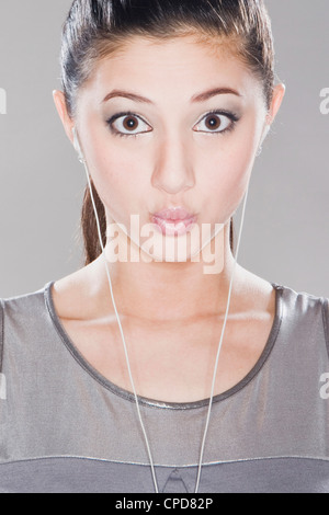 Surpris mixed race woman listening to headphones Banque D'Images