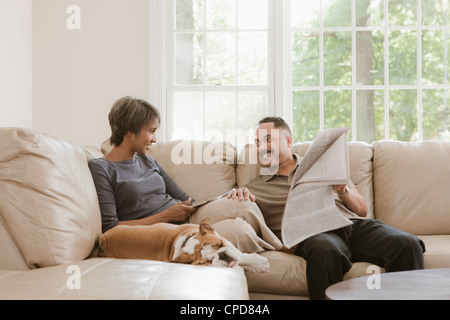 Couple relaxing on sofa avec bulldog Anglais Banque D'Images