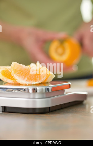 Hauts femme pesant sur l'échelle orange Banque D'Images