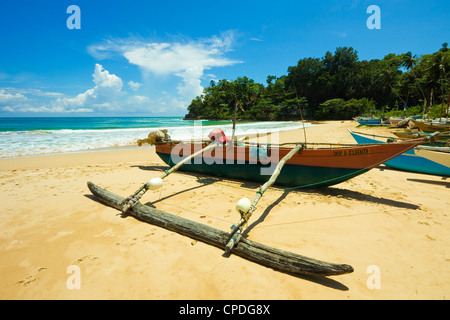 Outrigger bateau de pêche au calme cette retraite de la côte sud, la plage Talalla, près de Matara, Province du Sud, Sri Lanka, Asie Banque D'Images