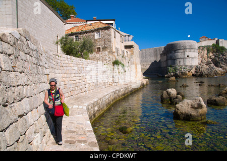 Balades touristiques féminin étroit sentier riverain sur la danse dans la ville de Dubrovnik Dalmatie central district Croatie Europe Banque D'Images