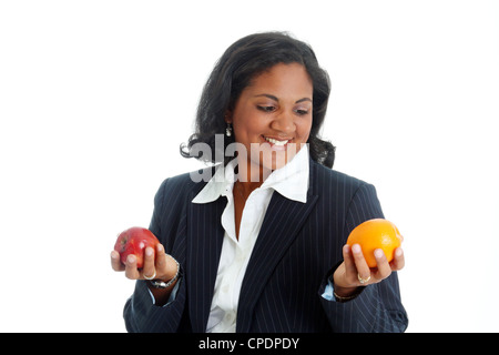 Femme comparer des pommes et des oranges sur un fond blanc Banque D'Images