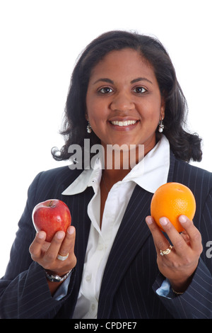 Femme comparer des pommes et des oranges sur un fond blanc Banque D'Images