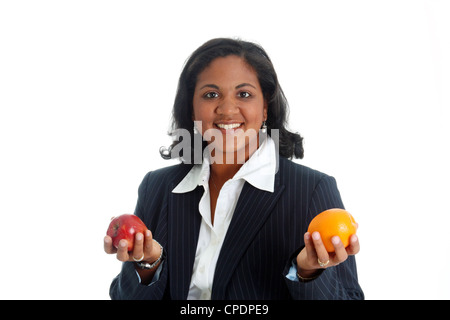 Femme comparer des pommes et des oranges sur un fond blanc Banque D'Images