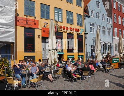 Restaurants et terrasses de restaurants dans les bâtiments peints dans les (anciens) red-light district Nyhavn de Copenhague, Danemark Banque D'Images