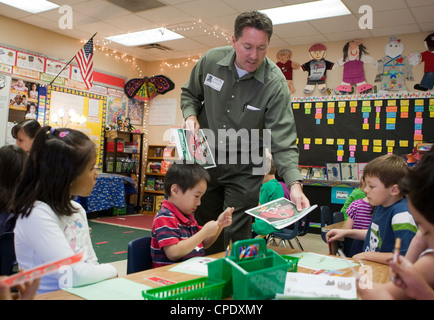 Dans la formation des enseignants de sexe masculin Anglo, interagit avec le groupe multi-ethnique des élèves de maternelle de l'école publique un Texas Banque D'Images