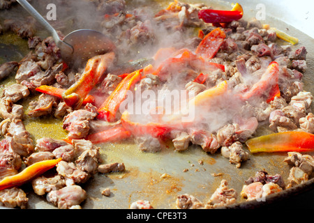 La Paella de l'Espagne Premiers pas la cuisson grande casserole de poulet et poivron rouge Banque D'Images