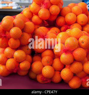 Fruits oranges sur marché en sacs rouge Banque D'Images