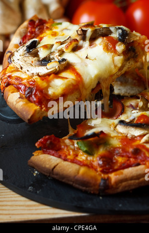 Tranche de jambon et champignons pizza de fromage mozzarella fondu filandreuse Banque D'Images