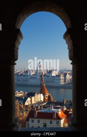 Le parlement (Orszaghaz) et du Danube à travers arcades de Bastion des Pêcheurs (Halaszbastya), Buda, Budapest, Hongrie, Europe Banque D'Images