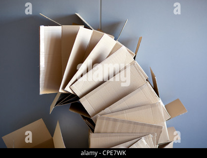 Carton Boîtes ouvertes empilés sur des panneaux forme du cercle sur le mur gris Banque D'Images