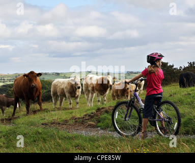 Une fille de 8 ans, bénéficie d'une promenade en vélo à travers la campagne sur une journée ensoleillée. Banque D'Images