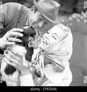 Libre à partir de 1960, montrant un couple avec leur petit chien. Banque D'Images