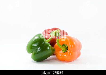 Trois vert, jaune et orange de poivrons de couleur sur un fond blanc. Banque D'Images