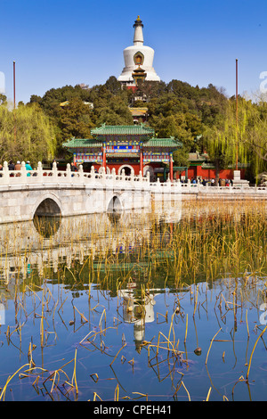 La Pagode blanche dans le parc Beihai, Beijing, Chine, reflété dans le lac sur une journée ensoleillée au début du printemps. Banque D'Images