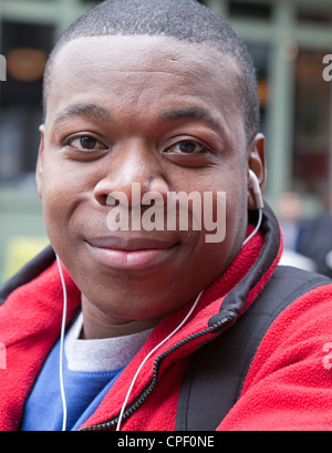 Un jeune homme écoute de la musique pendant l'attente à l'extérieur de la ville de New York. Banque D'Images