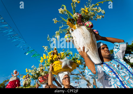Les disciples des Candombles portent des figurines religieuses et des fleurs pendant la procession en l'honneur de Yemanjá à Amoreiras, Bahia, Brésil. Banque D'Images
