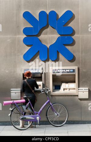 Femme à l'aide de Royal Bank of Scotland machine ATM, London, England, UK Banque D'Images