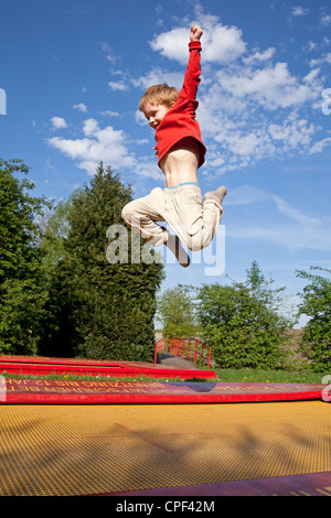 Jeune garçon sur un trampoline, parc Serengeti, Hodenhagen, Basse-Saxe, Allemagne Banque D'Images