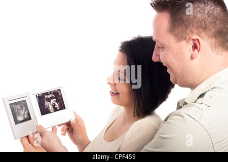 Happy pregnant couple looking at ultrasound photos de bébé, isolé sur fond blanc. Banque D'Images