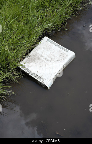 Broken XBox 360 abandonnés dans une flaque d'eau sur le côté de la route Banque D'Images