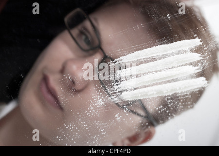 Close up de lignes de cocaïne et l'intoxiqué businesswoman reflétée dans le miroir. Banque D'Images