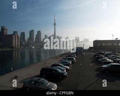 Voitures garées sur le stationnement du traversier à destination de l'aéroport Billy Bishop de Toronto et mauvaise vue tôt le matin de la Tour CN depuis l'île de Toronto, en Ontario, au Canada Banque D'Images