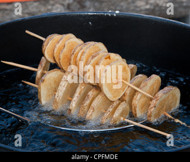 Tranches de pommes de terre cuites dans la fondue de pitchfork. Banque D'Images