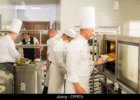 Groupe de cuisiniers en cuisine professionnelle préparer vos repas au restaurant Banque D'Images