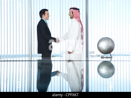 Deux hommes d'une poignée de main dans une salle de conférence. Banque D'Images