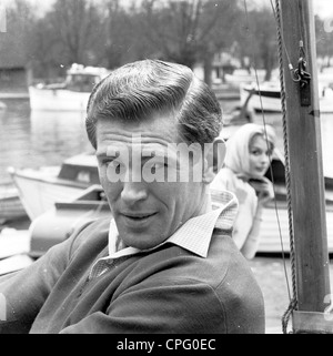 Une publicité à partir d'années 60 pour les produits pour les cheveux, montrant un homme à un chantier naval avec une femme admirant ses cheveux. Banque D'Images