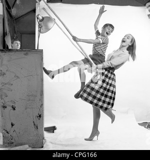 Se référant toujours à partir de 1960 montrant la mère et l'enfant dans un studio photographique faisant semblant d'être sur une balançoire. Banque D'Images