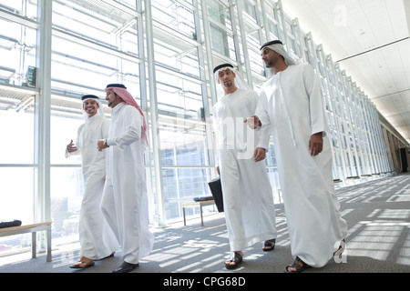 Quatre hommes d'affaires arabes à parler tout en parlant dans le couloir. bureau Banque D'Images