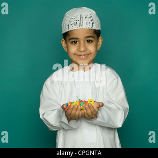 Boy (8-9) holding alphabets colorés, smiling, portrait Banque D'Images