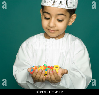 Boy (8-9) holding alphabets colorés, smiling, portrait Banque D'Images