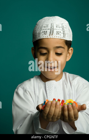 Garçon (8-9 ans), alphabets colorés holding smiling Banque D'Images