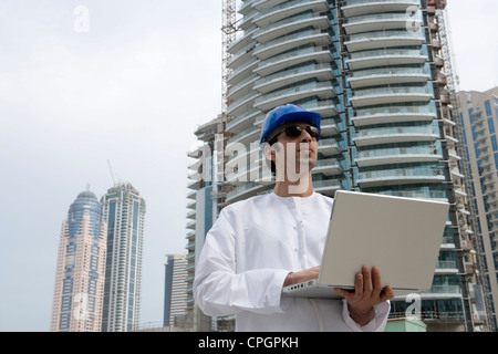 Businessman wearing hardhat and using laptop at construction site Banque D'Images